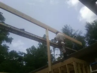 Carpenter setting a ridge beam over a new addition frame — Ice Dam Removal by Roofing Brothers in Kingsbury