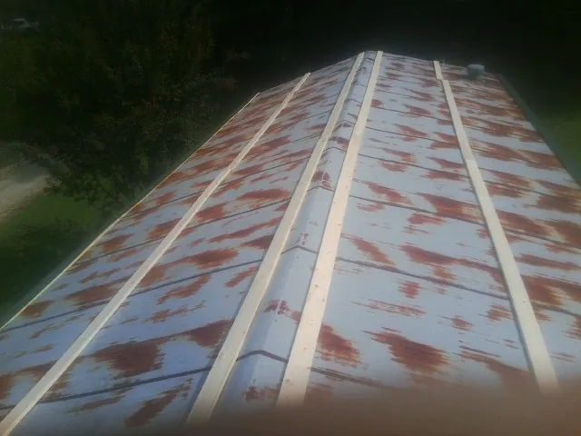 Rusted metal roof panels with new wood purlins before replacement — Storm Damage Roof Repair in Kingsbury by Roofing Brothers